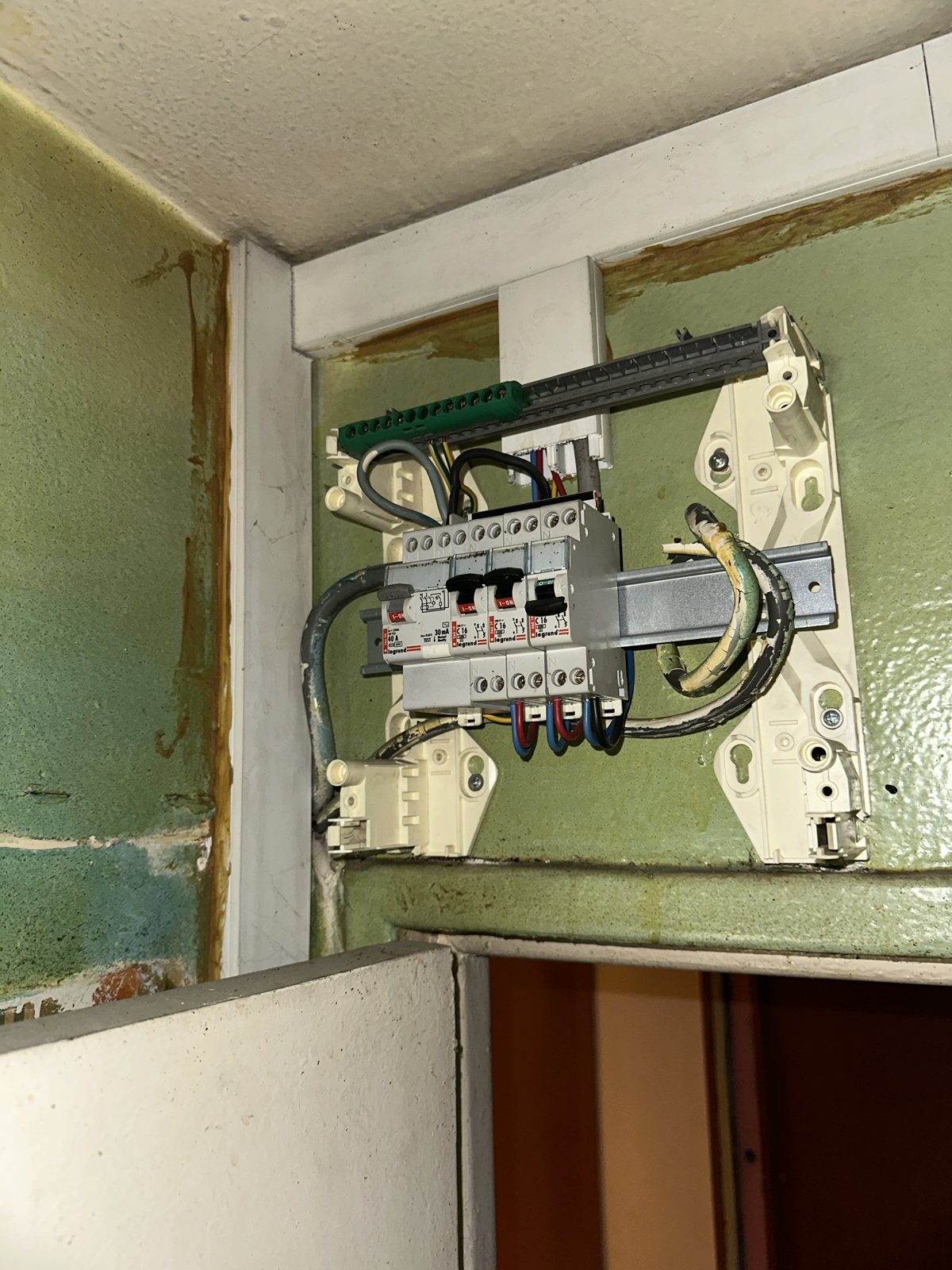 Ancien tableau électrique dans une salle de bain, non conforme