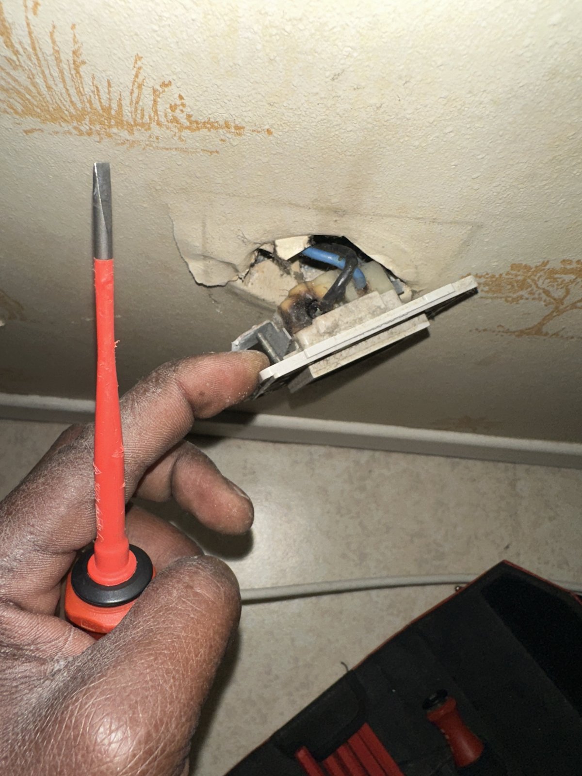 Fil électrique dénudé et noirci découvert en plafond